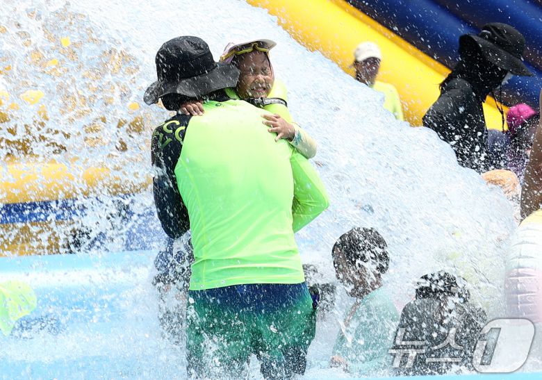 전국에 무더운 더위가 이어지는 26일 서울 성북구 숭덕초등학교에 마련된 성북문화바캉스 물놀이장에서 가족들이 즐거운 시간을 보내고 있다. 2025.7.26/뉴스1 ⓒ News1 김민지 기자