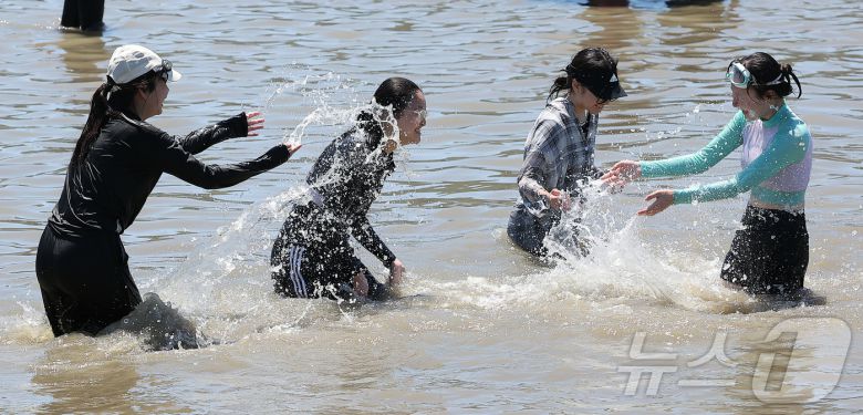 전국 대부분 지역에 폭염특보가 내려진 27일 오후 인천 중구 을왕리 해수욕장을 찾은 시민들이 더위를 식히고 있다. 2025.7.27/뉴스1 ⓒ News1 김진환 기자