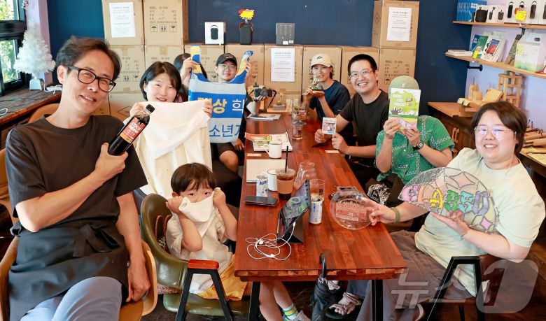 충북 괴산군 칠성면 옛 칠성시장 골목 '칠리단길'에 입점한 청년 창업자들이 각 상점의 상징물을 들고 카페 로컬즈에서 포즈를 취했다.(괴산군 제공).2025.7.29. 2025.7.29/뉴스1