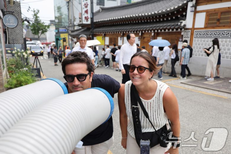 절기상 중복인 30일 서울 종로구의 한 삼계탕집 앞에서 더위에 지친 외국인 관광객이 냉풍기 바람으로 더위를 식히고 있다. 2025.7.30/뉴스1 ⓒ News1 박지혜 기자