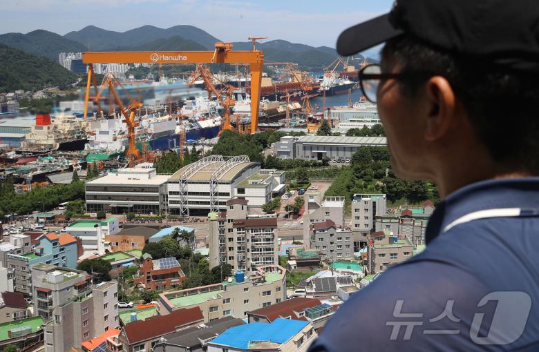 대미 수출 관세 인하와 조선업 투자를 골자로 한 한미 무역 협상이 타결된 31일 한 시민이 경남 거제시 아주동 주거단지 너머로 한화오션 거제사업장 대형 크레인을 바라보고 있다. 정부는 미국 도널드 트럼프 행정부와 무역 협상 합의에는 한국이 제안한 조선업 협력안인 '마스가'(MASGA) 프로젝트가 가장 크게 기여했다고 밝혔다. 2025.7.31/뉴스1 ⓒ News1 윤일지 기자
