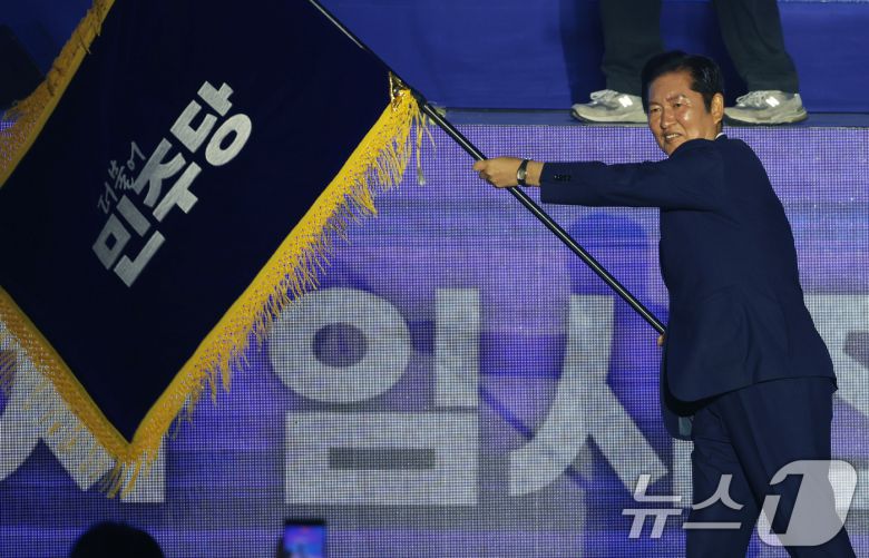 정청래 더불어민주당 신임 당대표가 2일 경기 고양시 킨텍스에서 열린 제2차 임시전국당원대회에서 당기를 흔들고 있다. (공동취재) 2025.8.2/뉴스1 ⓒ News1 유승관 기자