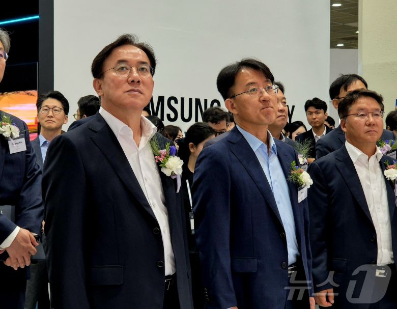 정철동 LG디스플레이 사장(왼쪽)과 이청 삼성디스플레이 사장(가운데)이 서울 강남구 코엑스에서 열린 'K-디스플레이 2025'에서 나란히 전시관을 둘러보고 있다. 2025.8.7/뉴스1 ⓒ News1 최동현 기자