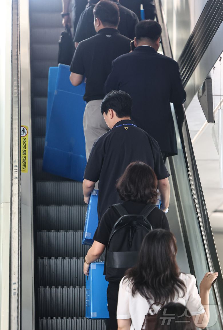 경기남부경찰청과 고용노동부 관계자들이 12일 인천시 연수구 포스코이앤씨 본사 사옥에서 압수품을 담기 위한 박스를 들고 이동하고 있다.  2025.8.12/뉴스1 ⓒ News1 김도우 기자
