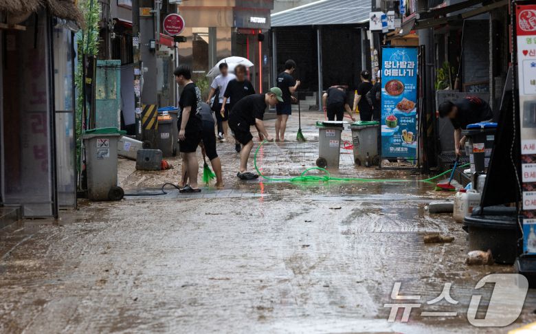 13일 오후 서울 은평구 연신내역 인근 상가 거리에서 상인들이 폭우로 인해 더러워진 거리를 청소하고 있다. 2025.8.13/뉴스1 ⓒ News1 이승배 기자