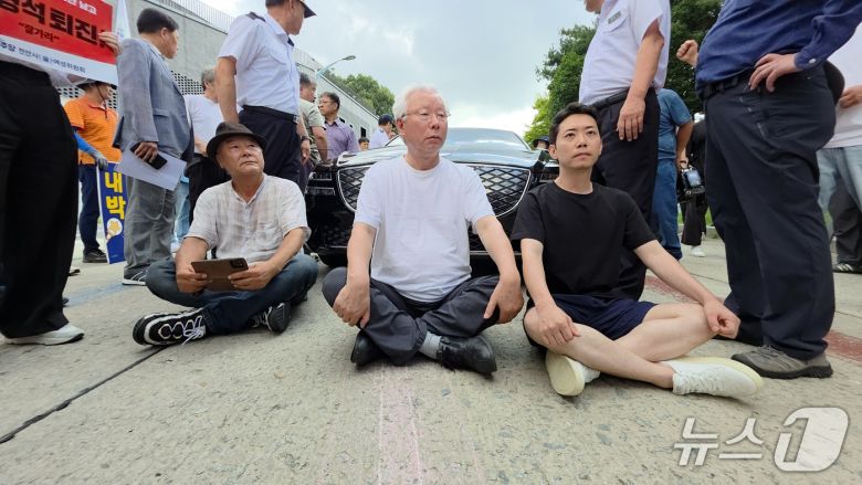 김형석 관장의 사퇴를 촉구하며 관장실을 점거 농성 중인 오주현 씨(오른쪽)가 지난 25일 김형석 관장의 출근을 저지하기 위해 차량을 막아서고 있다. 2025.8.25./뉴스1ⓒNews1 이시우 기자