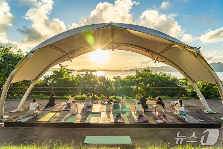 강화유니버스 참가자들이 강화도의 노을을 배경으로 요가를 하고 있는 모습(한국관광공사 제공)