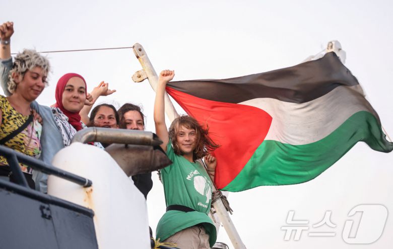 9월 25일(현지시간) 그리스 크레타섬 인근 해역에서 팔레스타인 가자지구로 향하던 '글로벌 수무드 함대'(GSF) 선박 위에서 그레타 툰베리(오른쪽)를 비롯한 활동가들이 승리를 뜻하는 손짓을 하고 있다. 2025.09.25. ⓒ 로이터=뉴스1 ⓒ News1 윤다정 기자