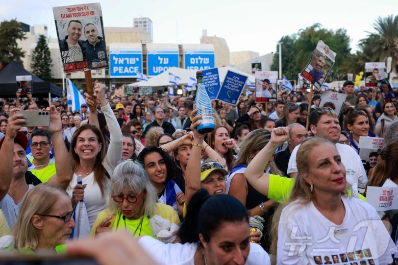팔레스타인 무장정파 하마스가 13일(현지시간) 이스라엘 인질 7명을 풀어주면서 인질 석방을 시작했다. 이스라엘 국민들이 광장에 모여 인질의 귀환 상황을 지켜보고 있다. 2025.10.13. ⓒ AFP=뉴스1