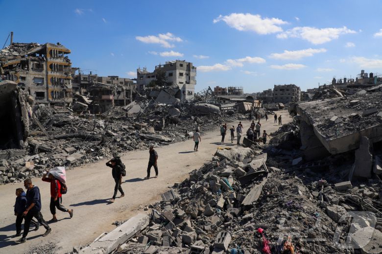 이스라엘과 하마스가 휴전에 돌입한 가운데 지난 14일(현지시간) 전쟁으로 파괴된 가자시티의 거리를 팔레스타인 주민들이 지나고 있다. 2025.10.14. ⓒ 로이터=뉴스1 ⓒ News1 류정민 특파원