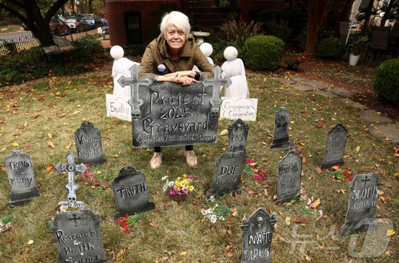 29일(현지시간) 미국 워싱턴DC 주민 도나 브레슬린(79)이 도널드 트럼프 미국 대통령을 풍자·비판하는 내용의 묘비로 꾸민 앞마당에 서 있다. 2025.10.29. ⓒ 로이터=뉴스1 ⓒ News1 윤다정 기자