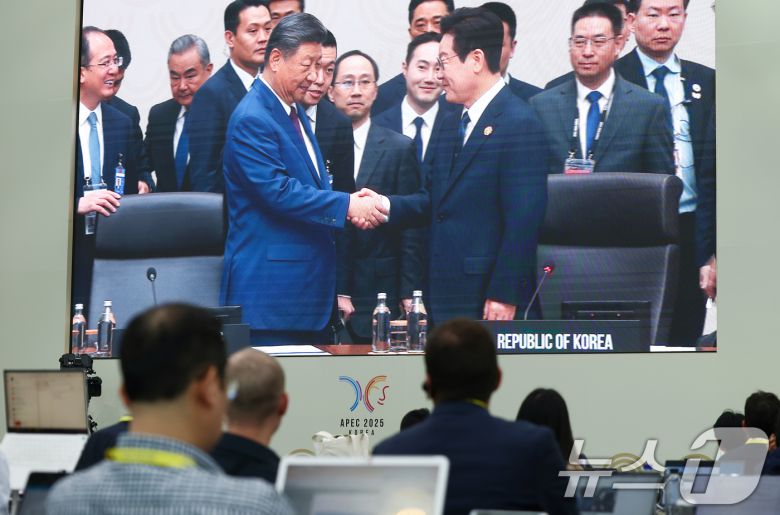 이재명 대통령과 시진핑 중국 국가주석이 2025 아시아태평양경제협력체(APEC) 정상회의 제2세션에서 악수하는 모습이 1일 경북 경주화백컨벤션센터(HICO) 인근 국제미디어센터(IMC)에 생중계되고 있다. 2025.11.1/뉴스1 ⓒ News1 김민지 기자