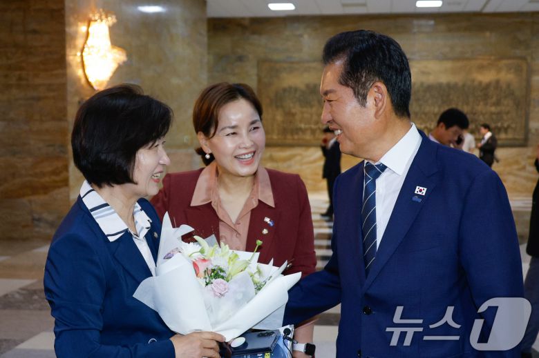지난 8월 21일 당시 추미애 신임 법제사법위원회 위원장이 서울 여의도 국회 본회의장 앞에서 법사위 직원들로부터 꽃다발을 받은 뒤 정청래 더불어민주당 대표의 축하를 받고 있다. 2025.8.21/뉴스1 ⓒ News1 안은나 기자