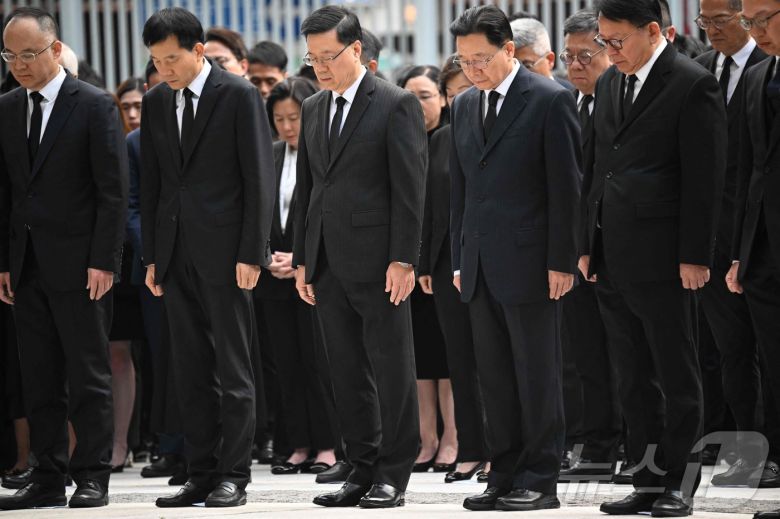 존 리 행정장관(앞줄 가운데) 등 홍콩 정청의 간부들이 정부청사 앞에서 아파트 화재 참사에 희생된 이들을 위해  3분간 묵념하고 있다. ⓒ AFP=뉴스1 ⓒ News1 박형기 기자