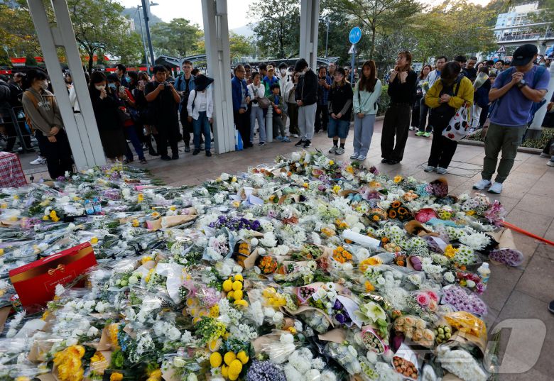 29일 홍콩 타이포 지역에서 설치된 아파트 화재 희생자 추모 공간에서 시민들이 헌화하고 있다. ⓒ 로이터=뉴스1 ⓒ News1 박형기 기자