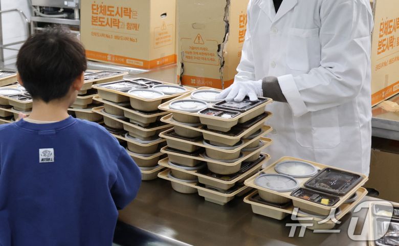 학교 급식·돌봄 업무 등에 종사하는 비정규직 노동자들이 총파업에 돌입한 4일 대전의 한 초등학교에서 어린이들이 도시락을 받고 있다. 2025.12.4/뉴스1 ⓒ News1 김기태 기자