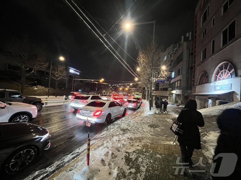 폭설이 내린 4일 오후 서울 종로구 자하문로에서 차량들이 눈길에 큰 정체를 빚자 시민들이 버스에서 내려 걸어가고 있다.2025.12.4/뉴스1 ⓒ News1 황기선 기자