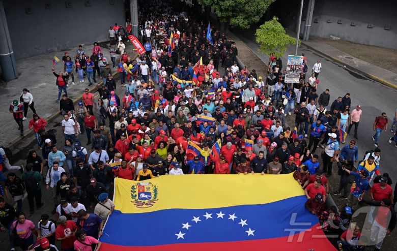 2025년 11월 25일 베네수엘라 카라카스에서 미국이 베네수엘라에 대한 군사 조치를 확대할 가능성에 반대하는 집회에 참가한 사람들이 베네수엘라 국기를 크게 흔들고 있다. 2025.11.25. ⓒ 로이터=뉴스1 ⓒ News1 이정환 기자