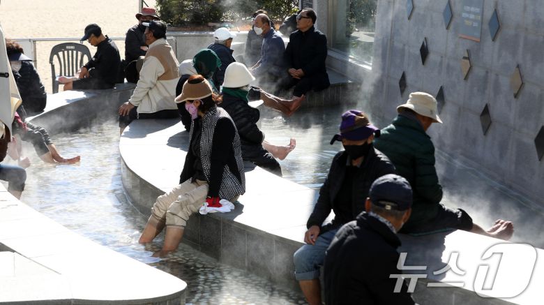 전국적으로 추위가 기승을 부린 3일 부산 해운대해수욕장 온천족욕탕을 찾은 시민들이 따뜻한 온천물에 발을 담그고 추위를 녹이고 있다. 2025.12.3/뉴스1 ⓒ News1 윤일지 기자