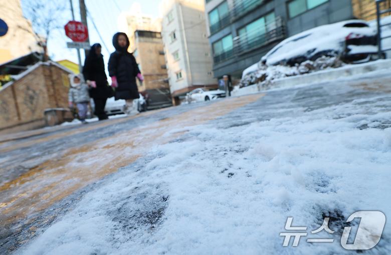 폭설 후 한파로 도로 곳곳이 얼어 붙은 5일 오전 서울 광진구에서 한 여성이 아이들과 빙판길을 걷고 있다. 2025.12.5/뉴스1 ⓒ News1 오대일 기자