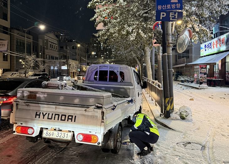 기습적인 폭설이 내린 4일 밤, 동대문경찰서 소속 경찰관이 눈길에 멈춰선 트럭에 안전 조치를 취하고 있다./동대문경찰서 제공