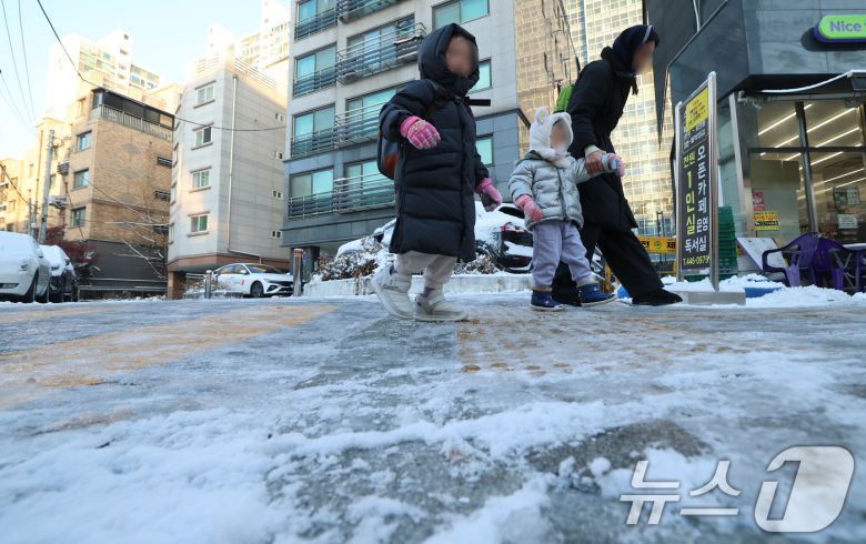 폭설 후 한파로 도로 곳곳이 얼어 붙은 5일 오전 서울 광진구에서 한 여성이 아이들과 빙판길을 걷고 있다. 2025.12.5/뉴스1 ⓒ News1 오대일 기자