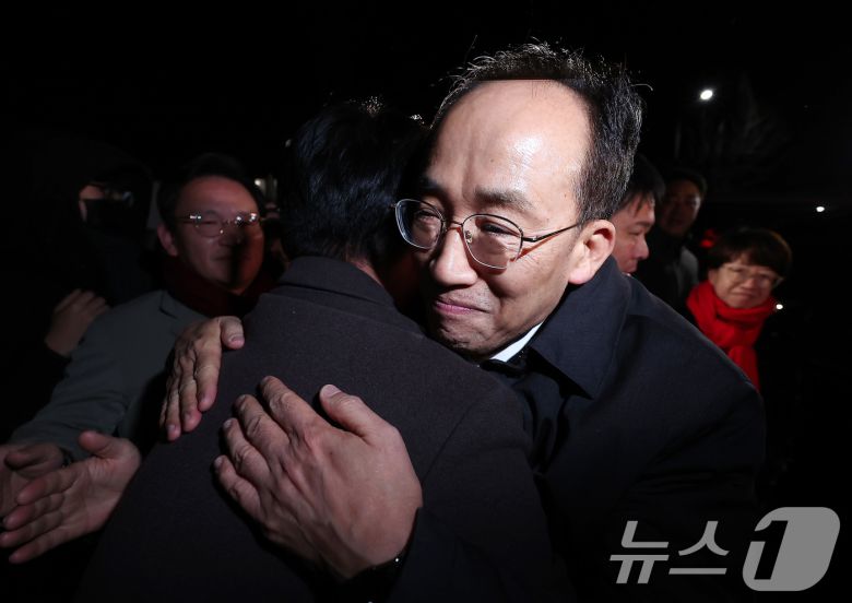 12·3 비상계엄 해제 요구안 표결 방해 의혹을 받는 추경호 국민의힘 의원이 지난 3일 새벽 구속 영장이 기각된 후 경기도 의왕시 서울구치소를 나서며 동료 의원들과 포옹하고 있다./뉴스1 ⓒ News1 김성진 기자