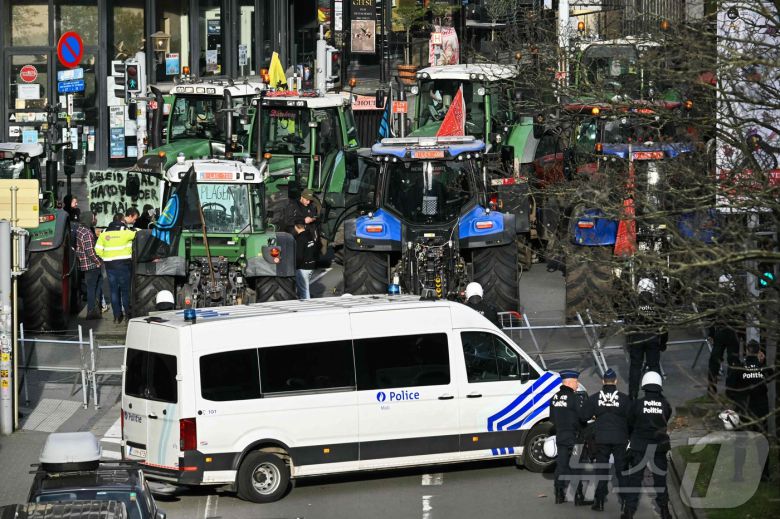 18일(현지시간) 벨기에 브뤼셀에서 열린 농민 시위 도중 유럽 의회 앞에 트랙터들이 집결해 경찰과 대치하고 있다. 2025.12.18. ⓒ AFP=뉴스1 ⓒ News1 이정환 기자