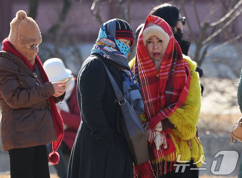 서울과 경기에 한파주의보가 내려진 25일 서울 종로구 경복궁을 찾은 외국인 관광객들이 강추위에 목도리 등 방한용품을 두른채 이동하고 있다.  2025.12.25/뉴스1 ⓒ News1 김진환 기자