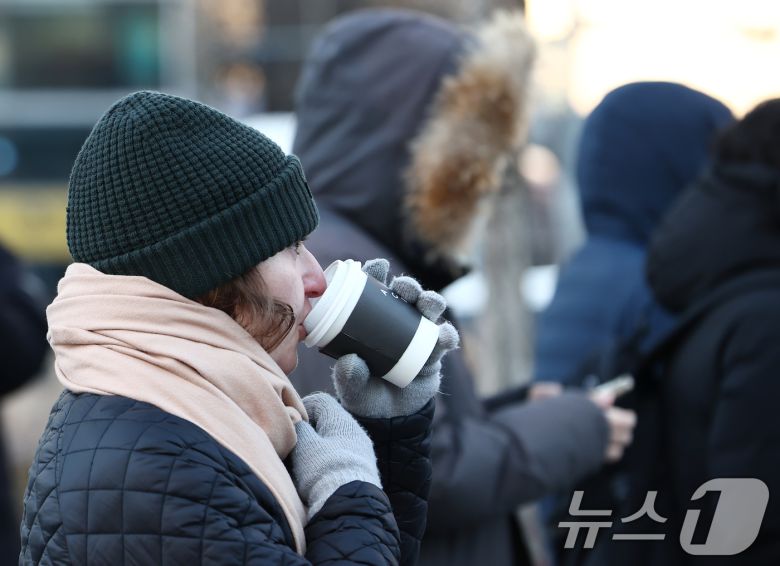 올겨울 첫 한파경보가 발령된 26일 오전 서울 종로구 광화문네거리에서 한 외국인이 뜨거운 음료를 마시고 있다. 2025.12.26/뉴스1 ⓒ News1 김민지 기자