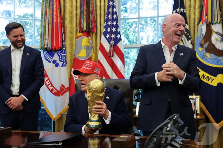 도널드 트럼프 미국 대통령이 8월 22일(현지시간) 워싱턴DC 백악관 집무실에서 '트럼프가 전부 옳았다!'(Trump Was Right About Everything!)라고 적힌 모자를 쓴 채 FIFA 월드컵 트로피를 들고 2026년 FIFA 월드컵 관련 발표를 하고 있다. 2025.08.22. ⓒ 로이터=뉴스1 ⓒ News1 윤다정 기자