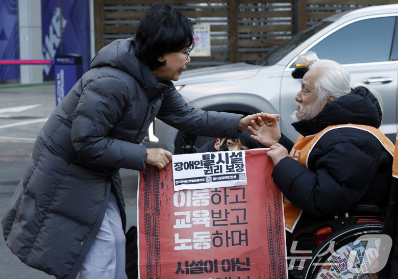 갑질·폭언 등 직장 내 괴롭힘 의혹이 제기된 이혜훈 초대 기획예산처 장관 후보자가 5일 오전 서울 중구 예금보험공사에 마련된 인사청문회 준비 사무실로 출근하며 박경석 전국장애인차별철폐연대 공동상임대표를 만나 장애인예산안에 대한 입장을 전달받고 있다. 2026.1.5/뉴스1 ⓒ News1 박정호 기자
