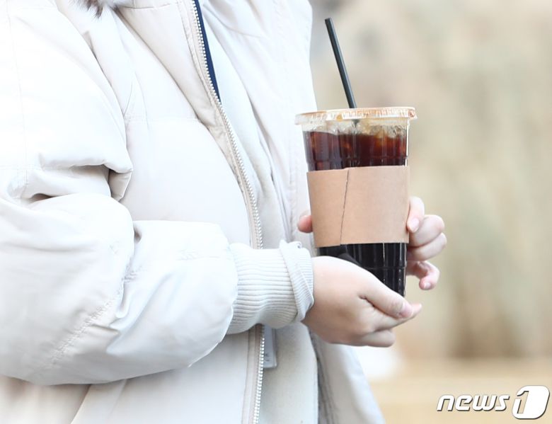 서울 종로구 광화문네거리에서 시민이 커피를 들고 발걸음을 옮기고 있다.ⓒ News1 김민지 기자