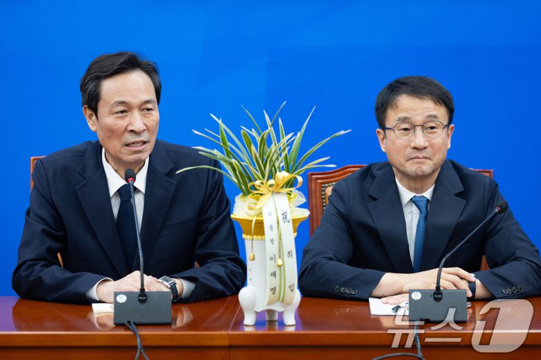 우상호 청와대 정무수석이 12일 서울 여의도 국회에서 한병도 더불어민주당 신임 원내대표의 취임을 축하하고 있다. 2026.1.12/뉴스1 ⓒ News1 유승관 기자