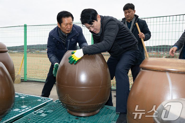 정청래 더불어민주당 대표가 14일 충남 당진시 백석올미마을기업을 방문해 장독 옮기기 작업을 하고 있다. 오른쪽은 한민수 당대표 비서실장. 2026.1.14/뉴스1 ⓒ News1 유승관 기자