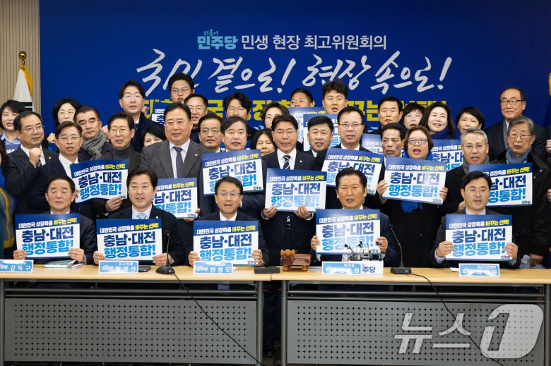 정청래 더불어민주당 대표와 한병도 원내대표를 비롯한 지도부와 참석자들이 14일 충남 서산시 서산축산종합센터에서 열린 충남 민생 현장 최고위원회의에 앞서 '충남·대전 행정통합' 피켓팅 퍼포먼스를 하고 있다. 2026.1.14/뉴스1 ⓒ News1 유승관 기자