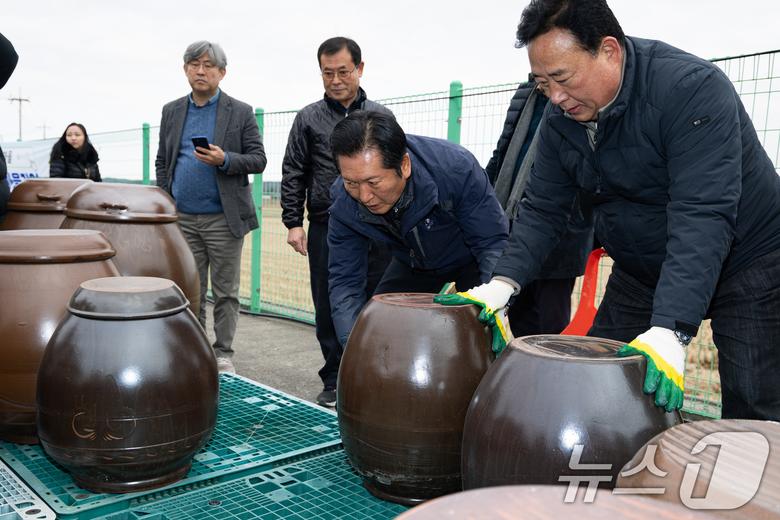 정청래 더불어민주당 대표가 14일 충남 당진시 백석올미마을기업을 방문해 장독 옮기기 작업을 하고 있다. 오른쪽은 어기구 농해수위원장. 2026.1.14/뉴스1 ⓒ News1 유승관 기자