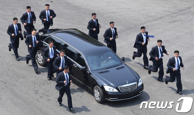 김정은 국무위원장이 27일 판문점 평화의 집에서 문재인 대통령과 오전 정상회담을 마치고 북측으로 가기 위해 차를 타고 이동하고 있다. 12명의 경호원들이 김 위원장의 차량을 에워싼 채 이동하고 있다. 2018.4.27/뉴스1 ⓒ News1 한국공동사진기자단