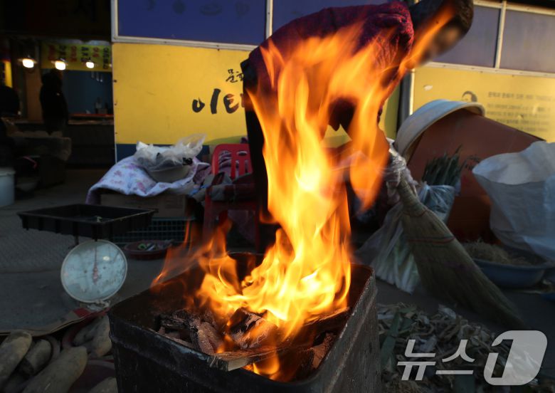 매서운 한파가 맹위를 떨친 14일 오전 대구 북구 칠성시장에서 상인이 모닥불을 쬐며 추위에 언 몸을 녹이고 있다. 2026.1.14/뉴스1 ⓒ News1 공정식 기자