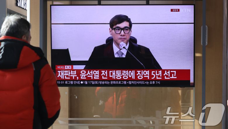 16일 오후 서울역에서 시민들이 체포 방해와 국무위원 심의권 침해 등 혐의로 기소된 윤석열 전 대통령에 대한 1심 선고 생중계를 지켜보고 있다. 서울 서초구 중앙지방법원에서 열린 1심 선고에서 백대현 부장판사가 판결문을 낭독한 뒤 징역 5년을 선고하는 모습. 2026.1.16/뉴스1 ⓒ News1 이광호 기자