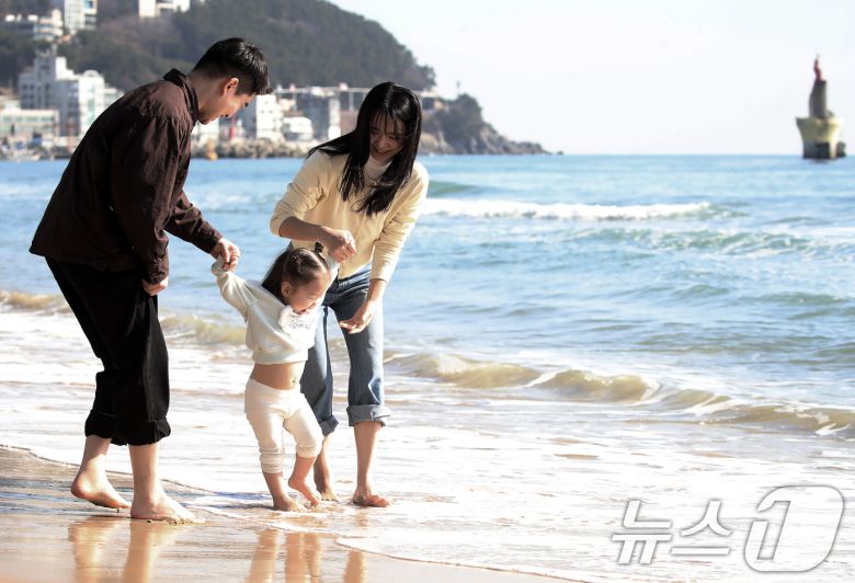 포근한 날씨를 보인 16일 부산 해운대해수욕장에서 가벼운 복장 차림을 한 가족이 바닷물에 발을 담그며 즐거운 시간을 보내고 있다. 2026.1.16/뉴스1 ⓒ News1 윤일지 기자