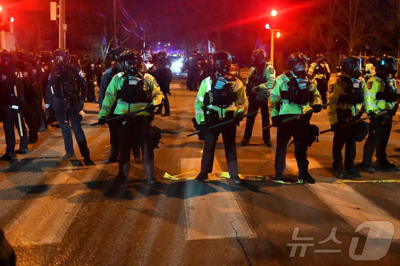 14일(현지시간) 미네소타주 미니애폴리스에서 시위대가 연방 법집행관과 충돌한 뒤 주 경찰관들이 도로에 줄을 지어 섰다. 이날 시 당국은 이민세관단속국(ICE) 요원이 베네수엘라 출신 남성을 총격했다고 밝혔다. 당국은 일주일 전 같은 도시에서 요원이 미국 여성에게 총격을 가해 사망하게 한 사건이 있었던 만큼 시민들에게 “침착함을 유지해 달라”고 당부했다.2026.1.14. ⓒ AFP=뉴스1 ⓒ News1 권영미 기자