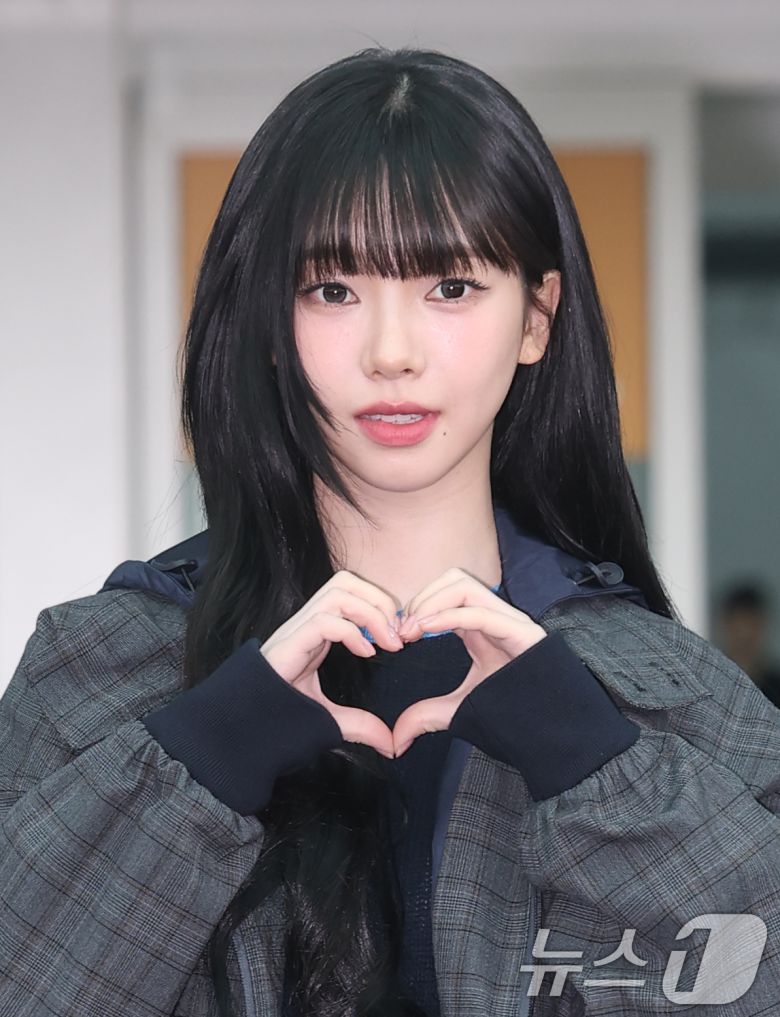 에스파 카리나가 해외 일정을 위해 16일 인천국제공항을 통해 밀라노로 출국하기 전 하트를 그리고 있다. ⓒ News1 권현진 기자