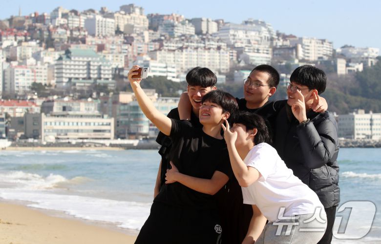 포근한 날씨를 보인 16일 부산 해운대해수욕장에서 반팔 차림을 한 시민들이 셀카를 찍으며 추억을 남기고 있다. 2026.1.16/뉴스1 ⓒ News1 윤일지 기자