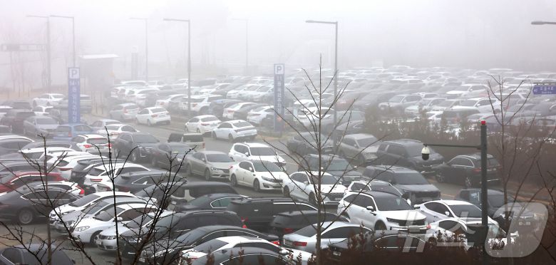세종을 비롯한 충청권·전북 지역에 초미세먼지 위기경보 ‘관심’ 단계가 발령되면서 16일 정부세종청사 출입구에서는 차량 2부제가 시행되어 홀수차량 출입을 통제하는 가운데 출입이 막힌 공무원들의 차량이 통제가 없는 옥외 주차장을 가득 메우고 있다.  2026.1.16/뉴스1 ⓒ News1 김기남 기자