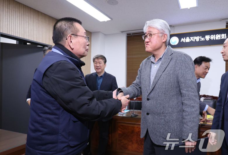 서울 영등포구 서울지방노동위원회에서 열린 특별조정위원회 2차 사후 조정회의에서 서울 시내버스 노사가 임금협상에 극적으로 합의한 뒤 박점곤 서울시버스노동조합 위원장과 김정환 서울시버스사업조합 이사장이 악수를 나누고 있다. 2026.1.15/뉴스1 ⓒ News1 박지혜 기자
