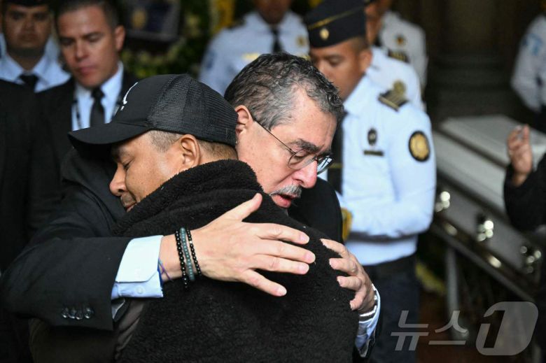 19일(현지시간) 과테말라시티 내무부 청사에서 열린 순직 경찰관 장례식에서 베르나르도 아레발루 과테말라 대통령이 유족을 안아주고 있다. 2026.01.19. ⓒ AFP=뉴스1 ⓒ News1 이정환 기자