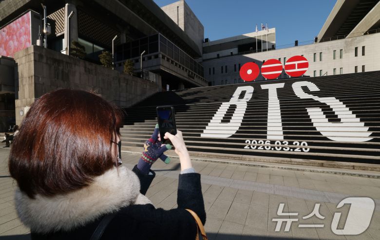 6일 오전 서울 종로구 세종문화회관 야외 계단에 설치된 BTS(방탄소년단)의 컴백 로고 조형물 앞에서 관광객이 기념촬영을 하고 있다. BTS는 3월 20일 컴백과 새 앨범 발매, 월드투어 일정을 공식 발표했다. 2026.1.6/뉴스1 ⓒ News1 임세영 기자