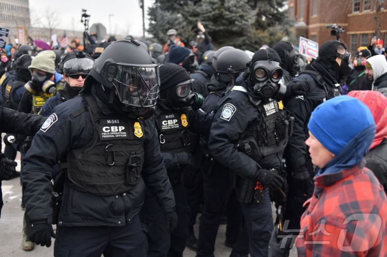 15일(현지시간) 미국 미네소타주 미니애폴리스에서 세관국경보호국(CBP) 요원들이 이민세관단속국(ICE) 반대 집회 중인 시위대와 대치하고 있다. 2026.01.15. ⓒ AFP=뉴스1 ⓒ News1 윤다정 기자