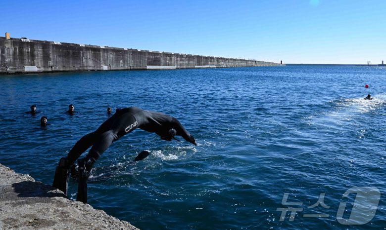 22일 강원 동해시 동해군항 1부두에서 SSU 5구조작전중대 대원들이 철인 심해잠수팀 선발 경기 마지막 종목인 릴레이 수영에 나서 차가운 바다로 몸을 던지고 있다.(해군1함대 제공, 재판매 및 DB 금지) 2026.1.22/뉴스1